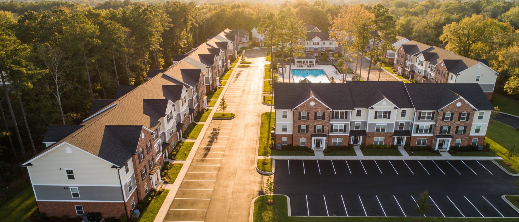 Aerial view of a well-maintained garden-style apartment community in suburban north Georgia at golden hour